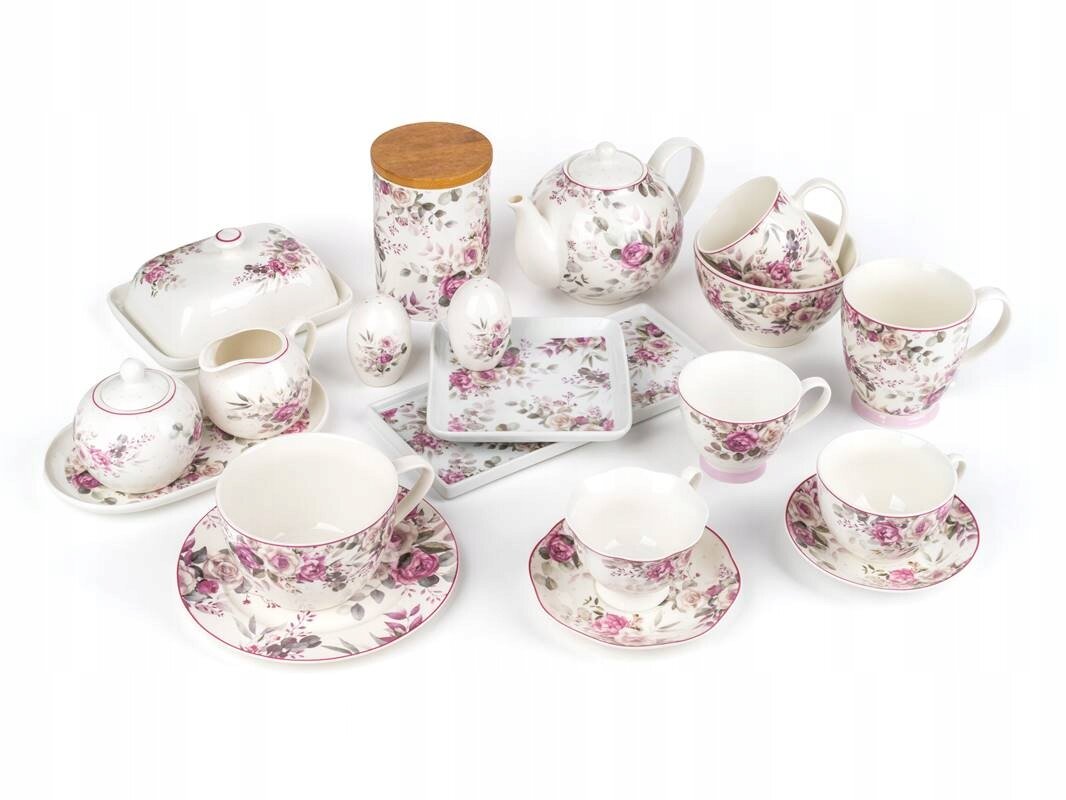 Zestaw porcelanowy z motywem różanym, składający się z filiżanek, spodków, dzbanka, cukiernicy, mlecznika, talerzyków i pojemnika z drewnianą pokrywką. Elementy mają biały kolor z różowymi kwiatami i delikatnymi zdobieniami.