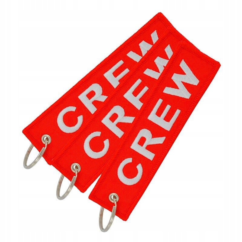Trzy czerwone breloki z napisem \'CREW\' w białym kolorze, każdy z metalowym kółkiem do zawieszenia.
