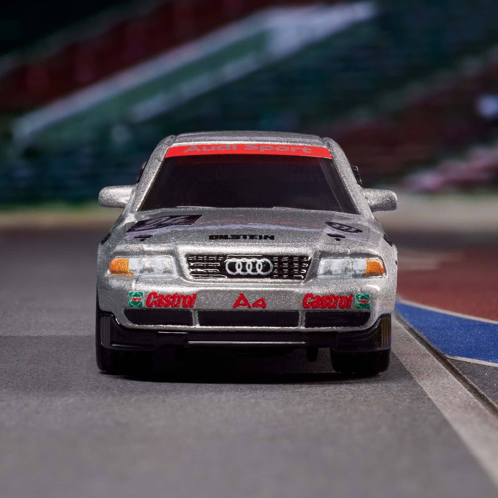 Model samochodu wyścigowego w kolorze srebrnym z widocznym logo Audi na przodzie. Na zderzaku znajdują się napisy \'Castrol\' i \'A4\'.