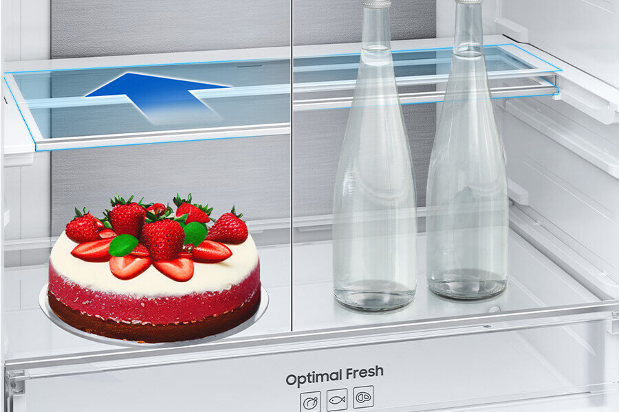 Składana półka - Samsung lodówka - Media Expert W lodówce znajduje się tort z truskawkami oraz dwie szklane butelki. Na szufladzie widoczny jest napis \'Optimal Fresh\' oraz ikony przedstawiające różne tryby przechowywania.