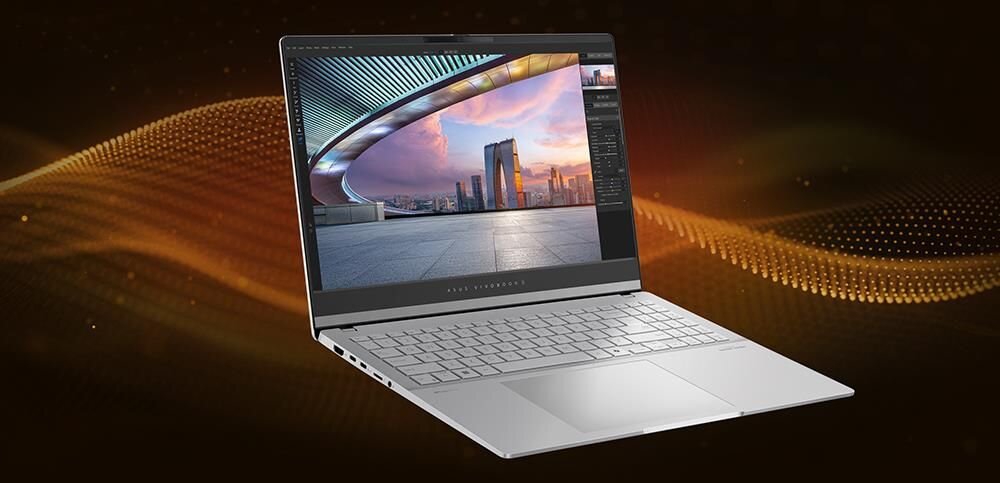 Laptop z otwartym ekranem wyświetlającym kolorowy krajobraz miejski. W tle widoczny jest abstrakcyjny wzór w odcieniach brązu i złota.