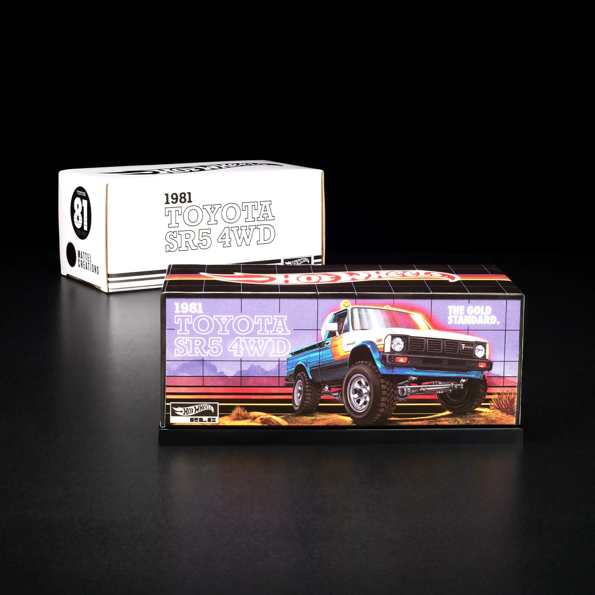 Na obrazie widoczne są dwa pudełka z napisem \'1981 TOYOTA SR5 4WD\'. Na jednym z nich znajduje się kolorowa ilustracja samochodu terenowego oraz napis \'THE GOLD STANDARD.\'.