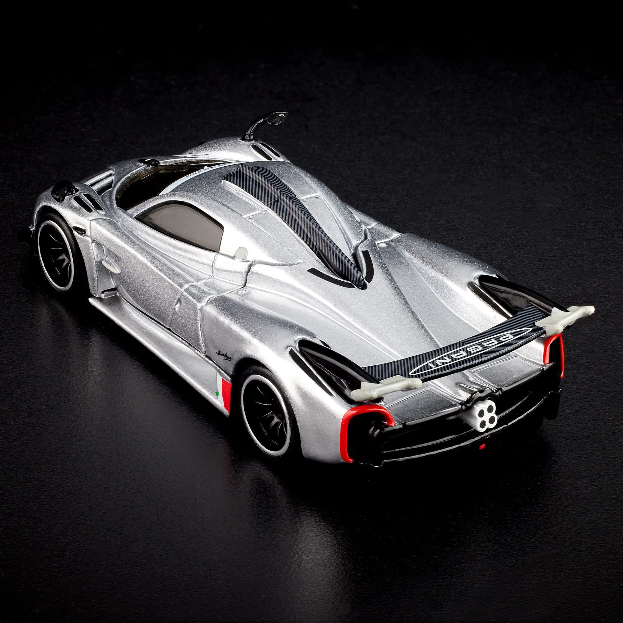 Model samochodu w srebrnym kolorze z czarnymi i czerwonymi detalami, widoczny z tyłu. Na tylnym spojlerze znajduje się napis \'Pagani\'.