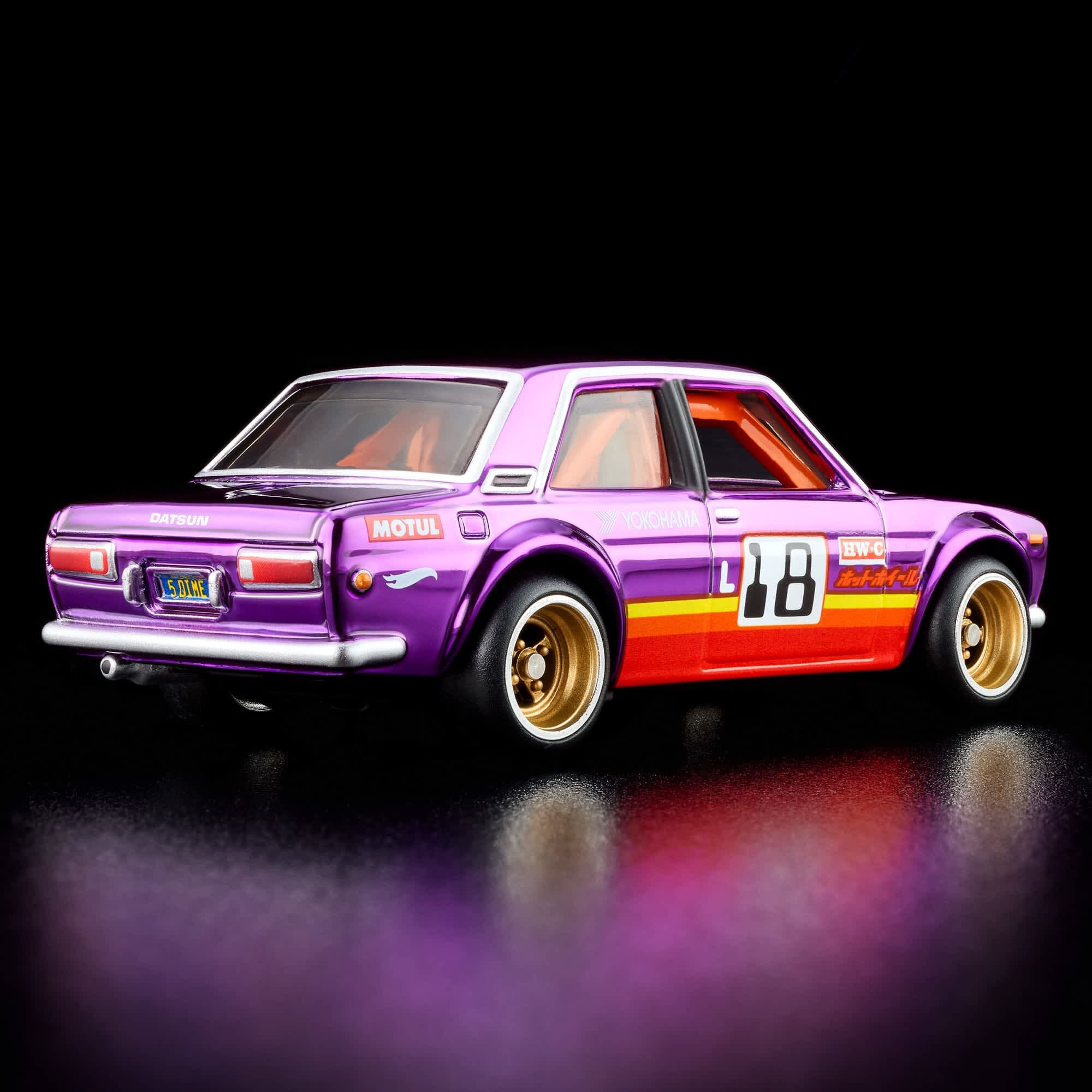 Model samochodu w kolorze fioletowym z numerem 18 na boku i złotymi felgami. Na tylnej części widoczne są napisy \'DATSUN\', \'MOTUL\' oraz tablica rejestracyjna z napisem \'510 RWC\'.