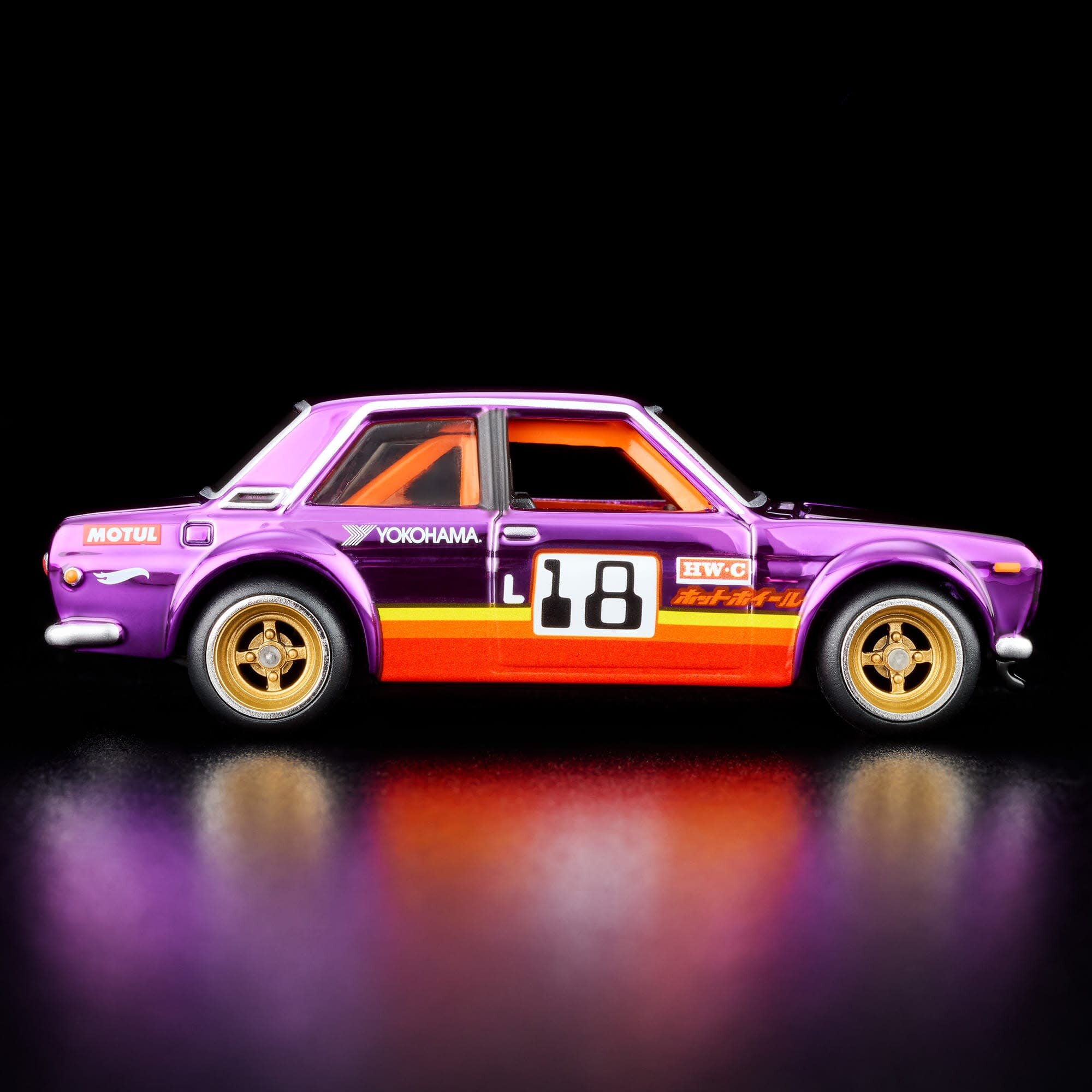 Model samochodu w kolorze fioletowym z numerem 18 na boku, posiada złote felgi i oznaczenia \'MOTUL\', \'YOKOHAMA\', \'HW-C\'.
