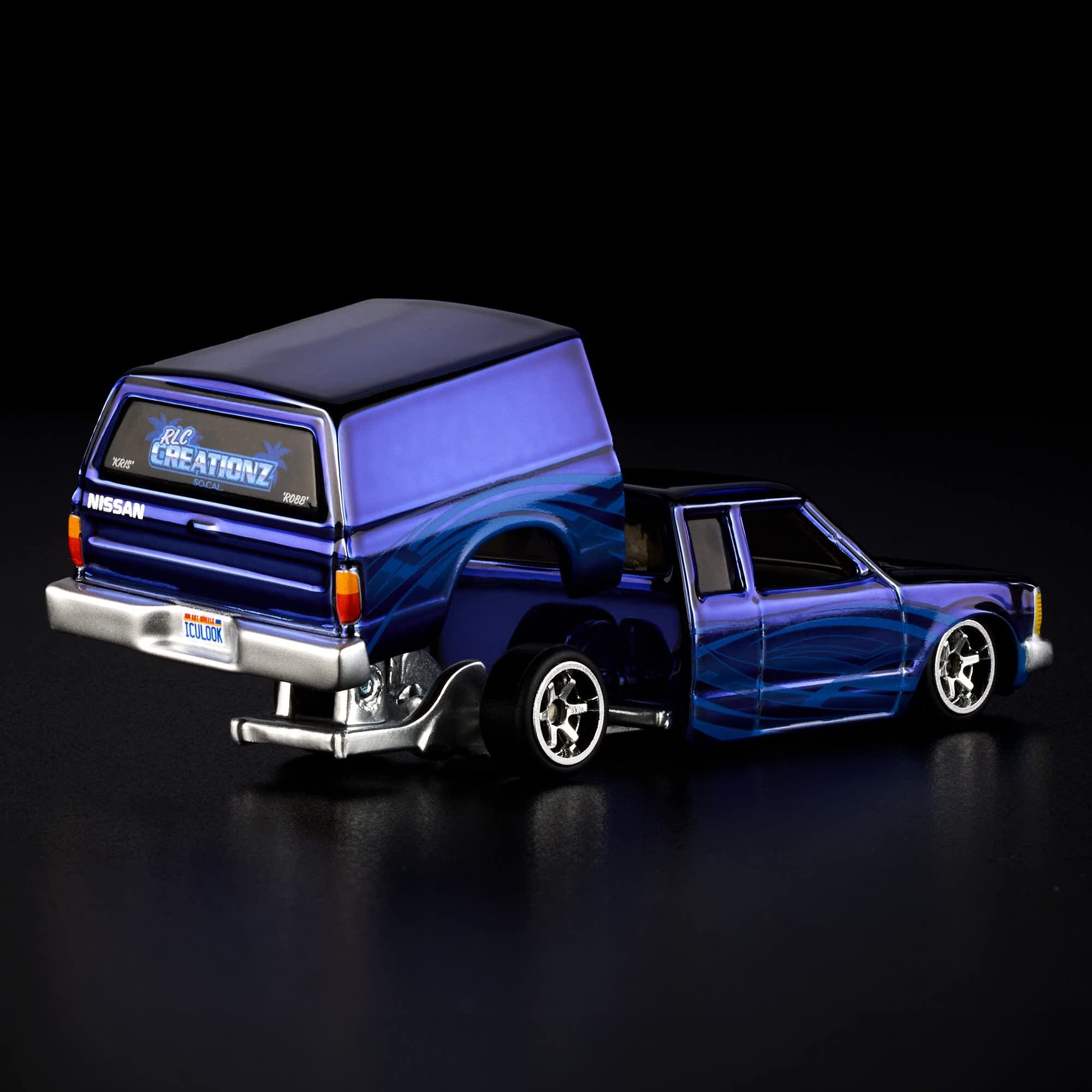 Model samochodu w kolorze niebieskim z napisem \'Nissan\' i \'RLC CREATIONZ\' na tylnej szybie. Pojazd ma srebrne felgi i tablicę rejestracyjną z napisem \'ICULOOK\'.