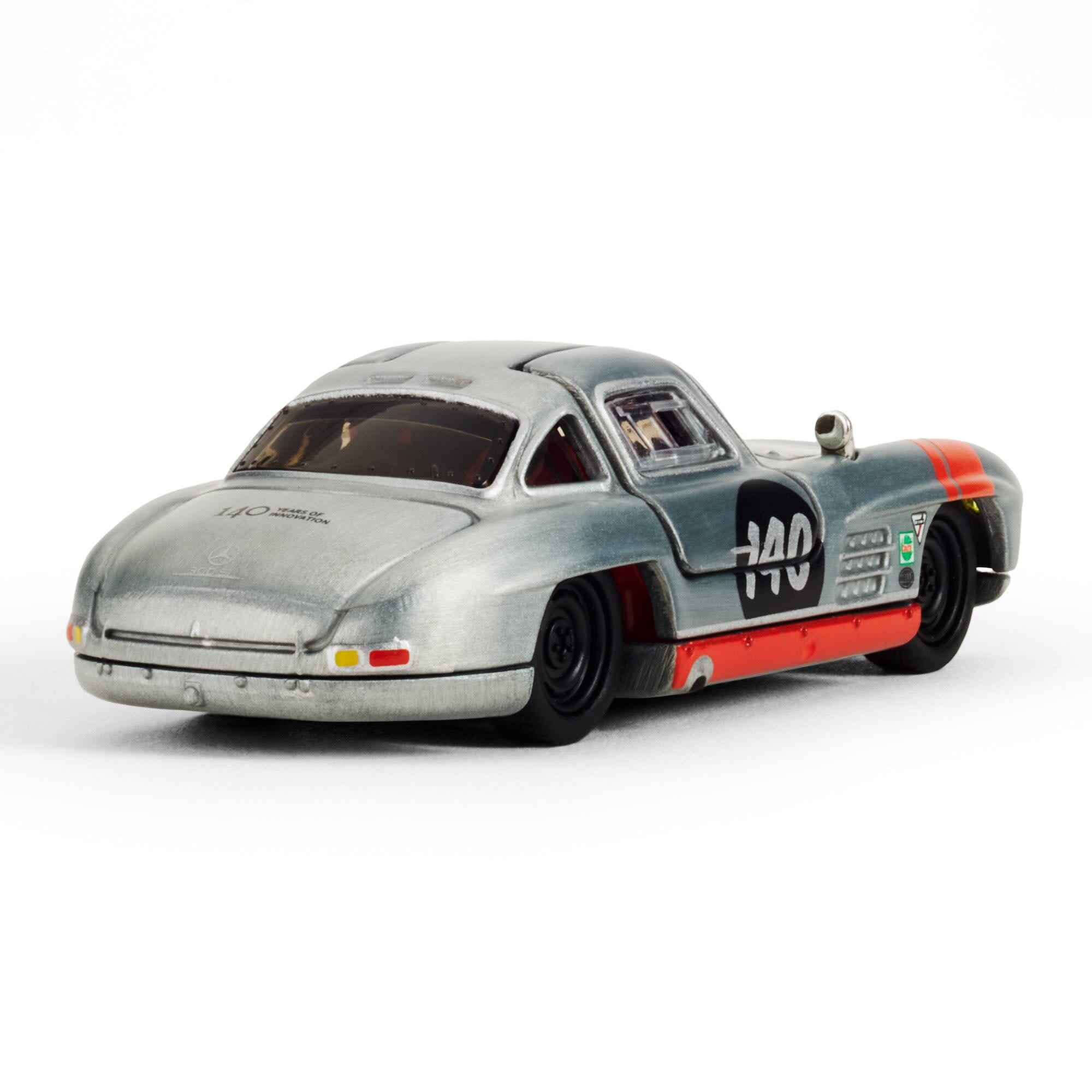 Model samochodu w skali 1:64 przedstawiający srebrny Mercedes-Benz 300 SL z numerem 140 na boku. Na tylnej części widoczny jest napis \'1/40\'.