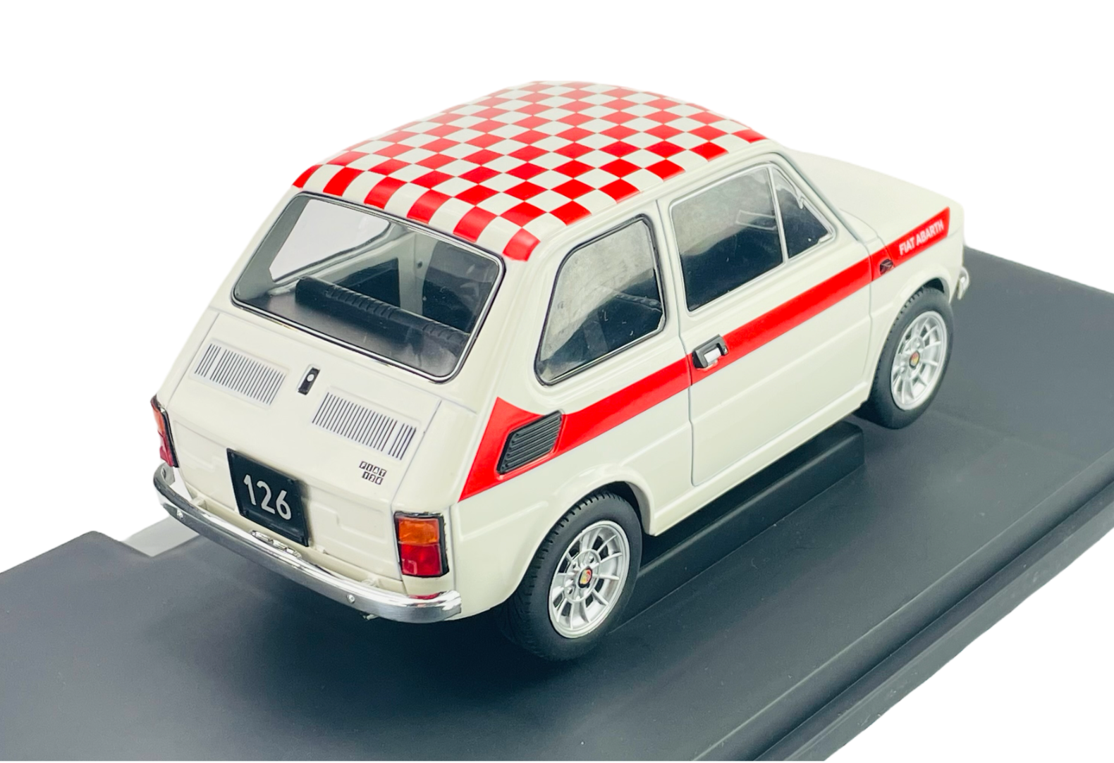 Model samochodu w skali 1:18 przedstawia biały Fiat 126 z czerwonymi pasami i szachownicą na dachu. Na tablicy rejestracyjnej widnieje numer \'126\'.