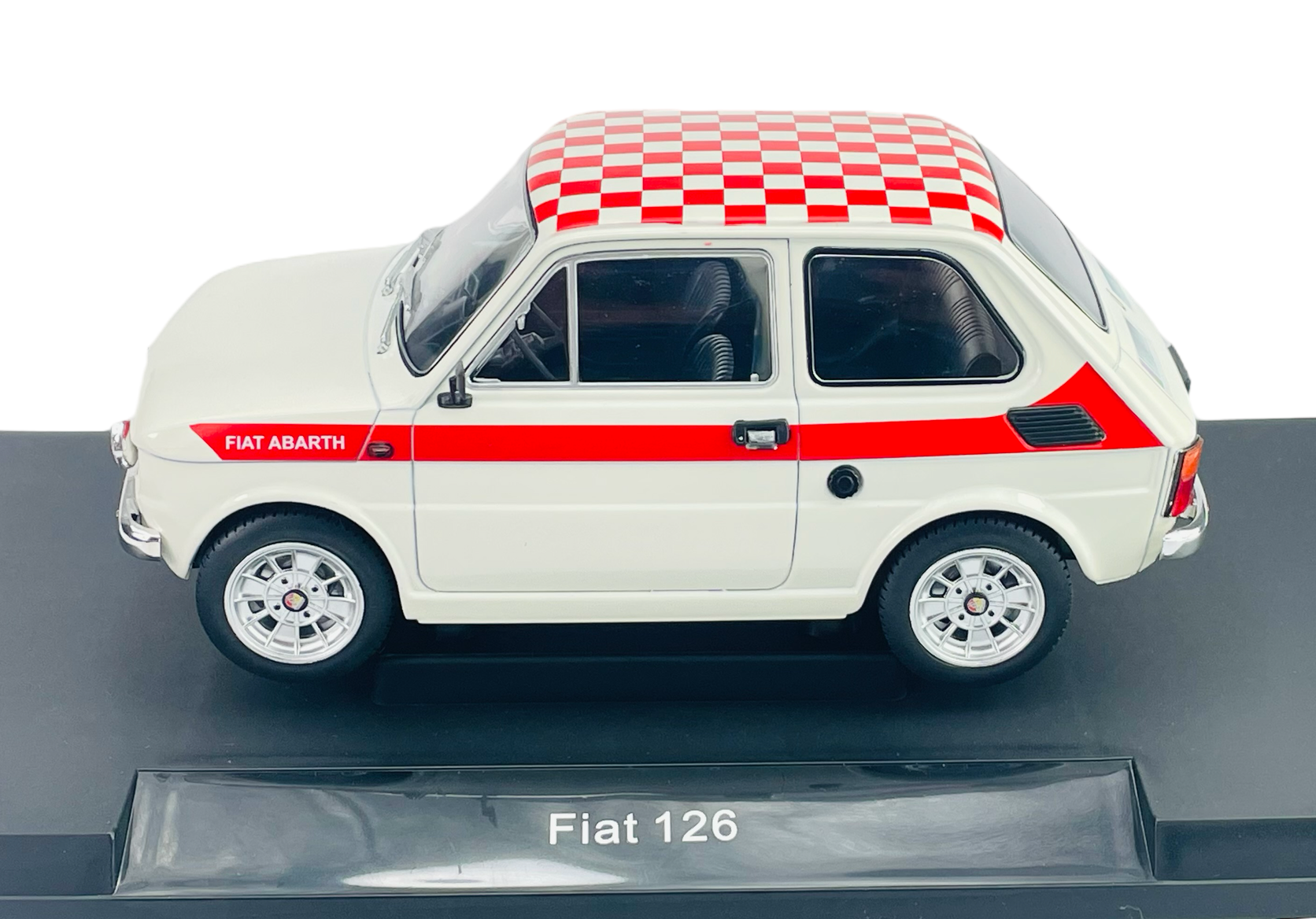 Model samochodu Fiat 126 w kolorze białym z czerwonymi detalami i wzorem szachownicy na dachu. Na podstawce widnieje napis \'Fiat 126\'.