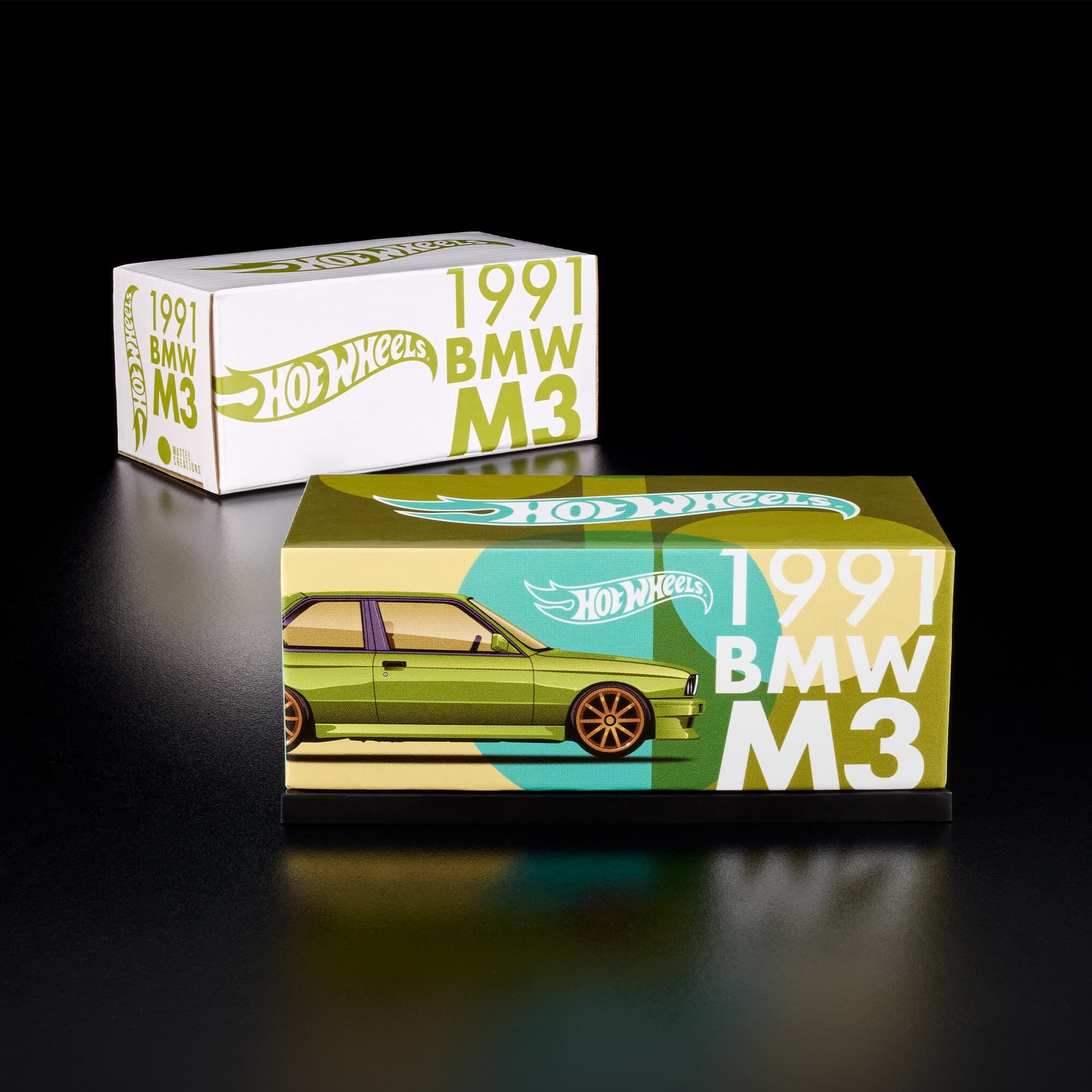 Na obrazie widoczne są dwa pudełka z napisem \'Hot Wheels 1991 BMW M3\'. Pudełko na pierwszym planie ma grafikę zielonego samochodu, a w tle znajduje się drugie pudełko z podobnym napisem.