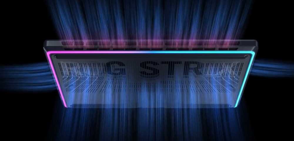 Obraz przedstawia dolną część laptopa z podświetleniem RGB w kolorach różowym i niebieskim. Na obudowie widoczny jest napis \'ROG STRIX\'.
