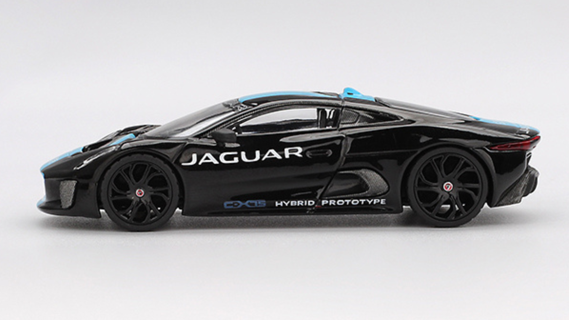 Model samochodu w kolorze czarnym z niebieskimi akcentami, z widocznym napisem \'JAGUAR\' oraz \'HYBRID PROTOTYPE\' na boku. Pojazd ma sportowy design z dużymi, czarnymi felgami.