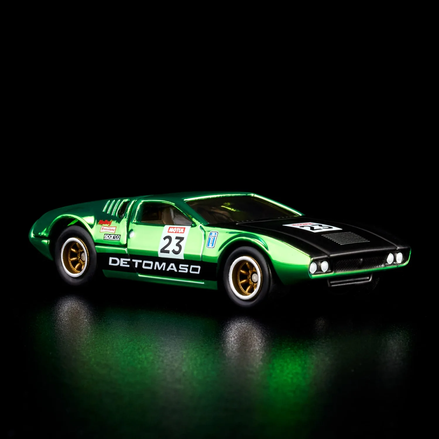 Model samochodu w kolorze zielonym z czarnymi elementami, oznaczony numerem 23 i napisem \'DETOMASO\'. Na boku widoczne są logotypy \'Motul\' i \'Sparco\'.