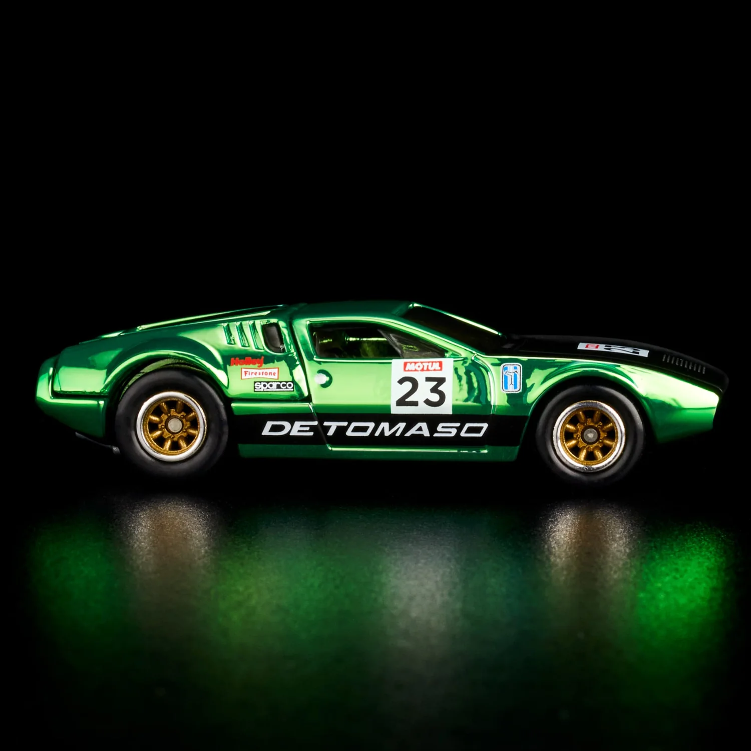 Model samochodu w kolorze zielonym z numerem 23 i napisem \'DE TOMASO\' na boku. Na pojeździe widoczne są loga \'Motul\', \'Firestone\' i \'Sparco\'.