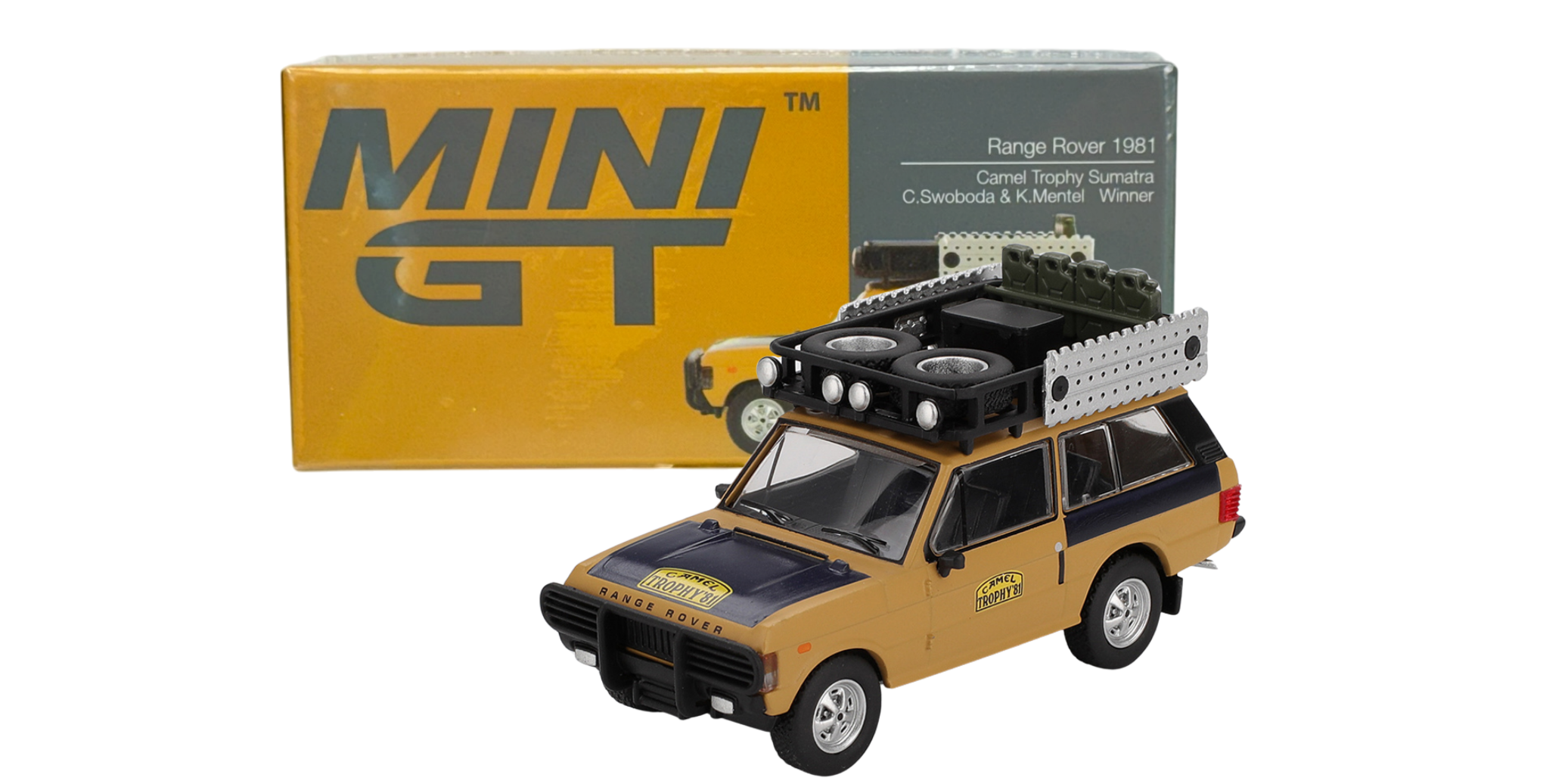 Model samochodu terenowego w kolorze żółtym z czarnymi elementami, z bagażnikiem dachowym i reflektorami. W tle pudełko z napisem \'MINI GT\' oraz \'Range Rover 1981 Camel Trophy Sumatra\'.
