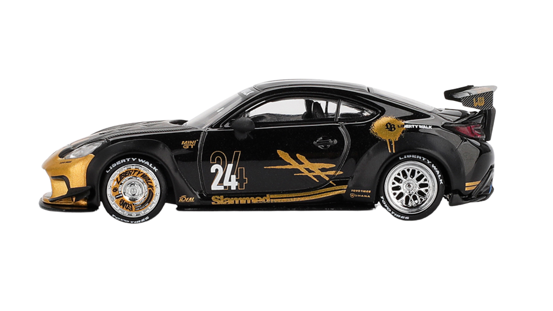 Model samochodu w kolorze czarnym z numerem 24 na boku, ozdobiony złotymi detalami i napisami \'Liberty Walk\' na oponach. Na karoserii widoczne są również napisy \'Slammed\' i logo \'Toyota\'.