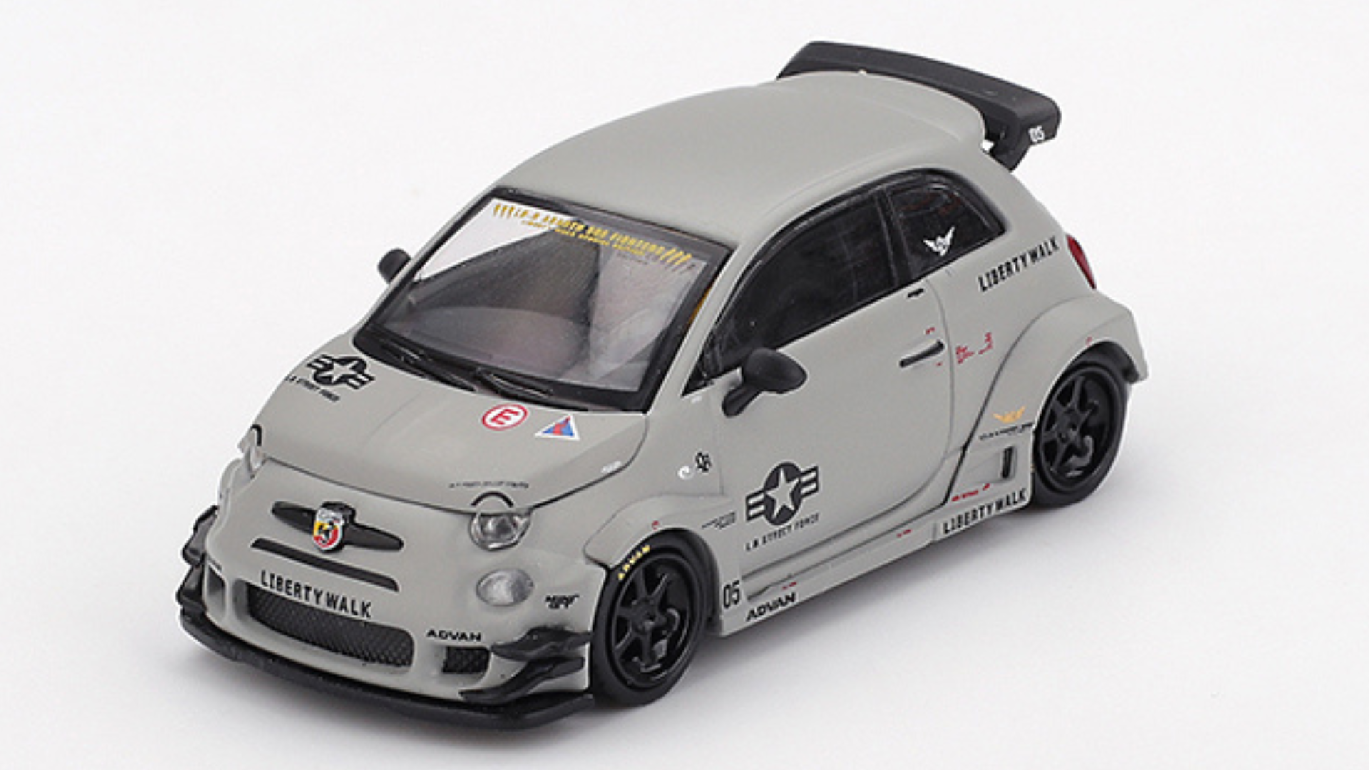 Model samochodu w skali 1:64, przedstawiający szary Fiat Abarth 595 z oznaczeniami Liberty Walk i różnymi naklejkami. Posiada czarne felgi i widoczne logo Abarth na przodzie.