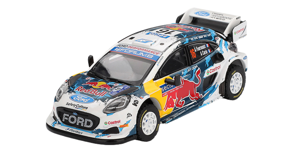 Model samochodu rajdowego z licznymi naklejkami sponsorów, w tym logo Ford, Red Bull i Castrol. Pojazd ma białe nadwozie z niebieskimi i żółtymi akcentami oraz dużym tylnym spojlerem.