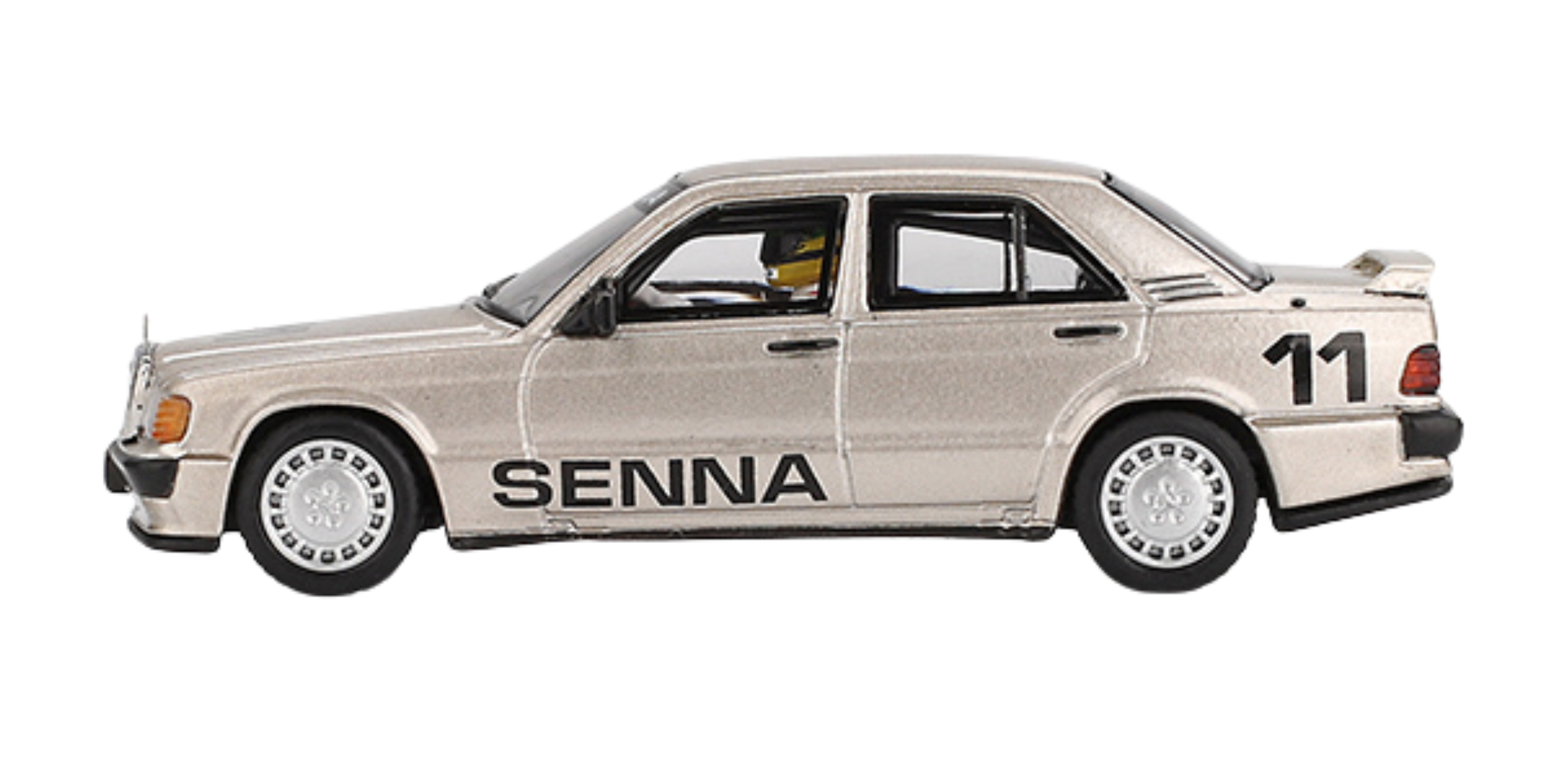 Model samochodu w kolorze srebrnym z napisem \'SENNA\' na boku i numerem \'11\' na tylnej części. Posiada szczegółowe odwzorowanie felg i elementów karoserii.