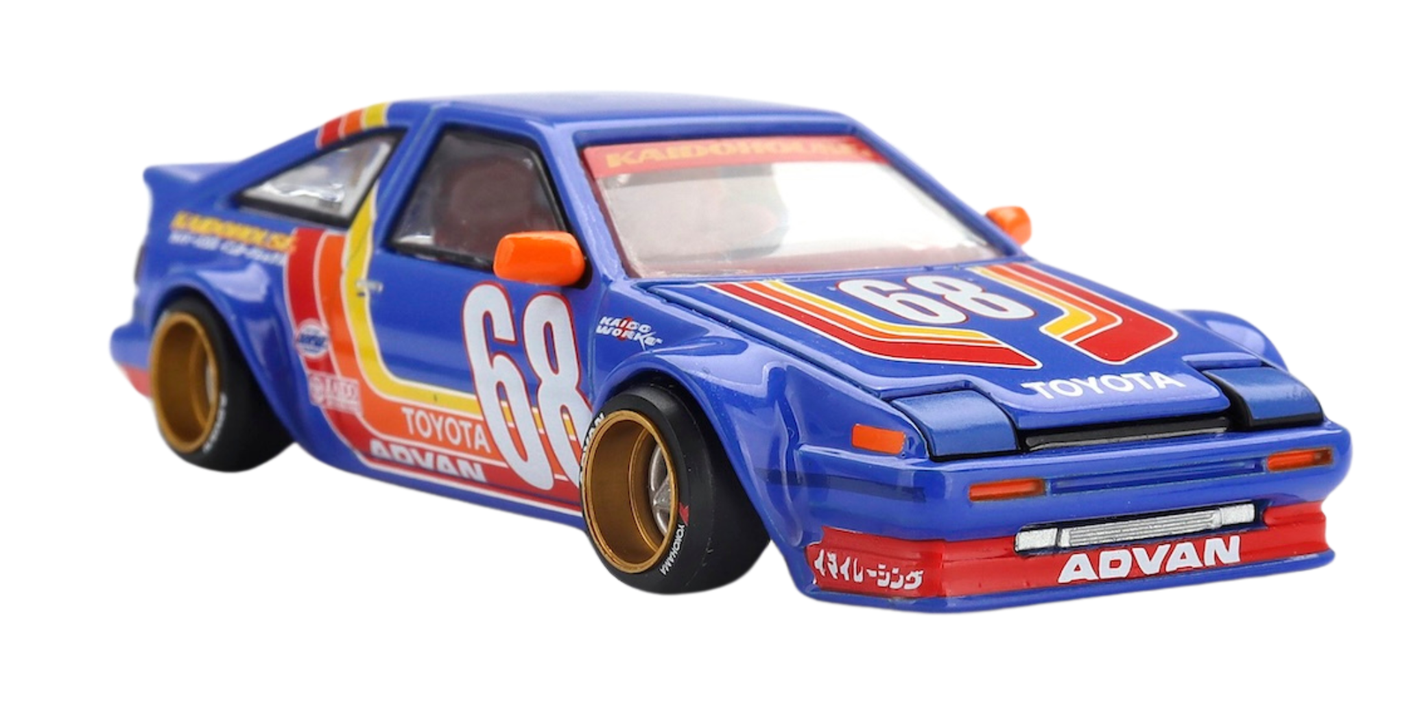 Model samochodu w skali 1:64 przedstawia niebieski pojazd z numerem 68 i napisami \'TOYOTA\' oraz \'ADVAN\'. Samochód ma czerwone i żółte akcenty oraz złote felgi.