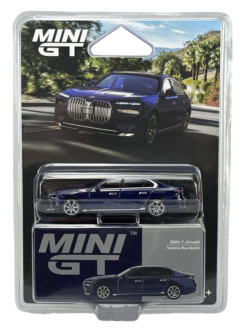 Opakowanie z modelem samochodu w skali 1:64, przedstawiające niebieski pojazd z napisem \'MINI GT\' oraz \'BMW i7 xDrive60 Tanzanite Blue Metallic\'.