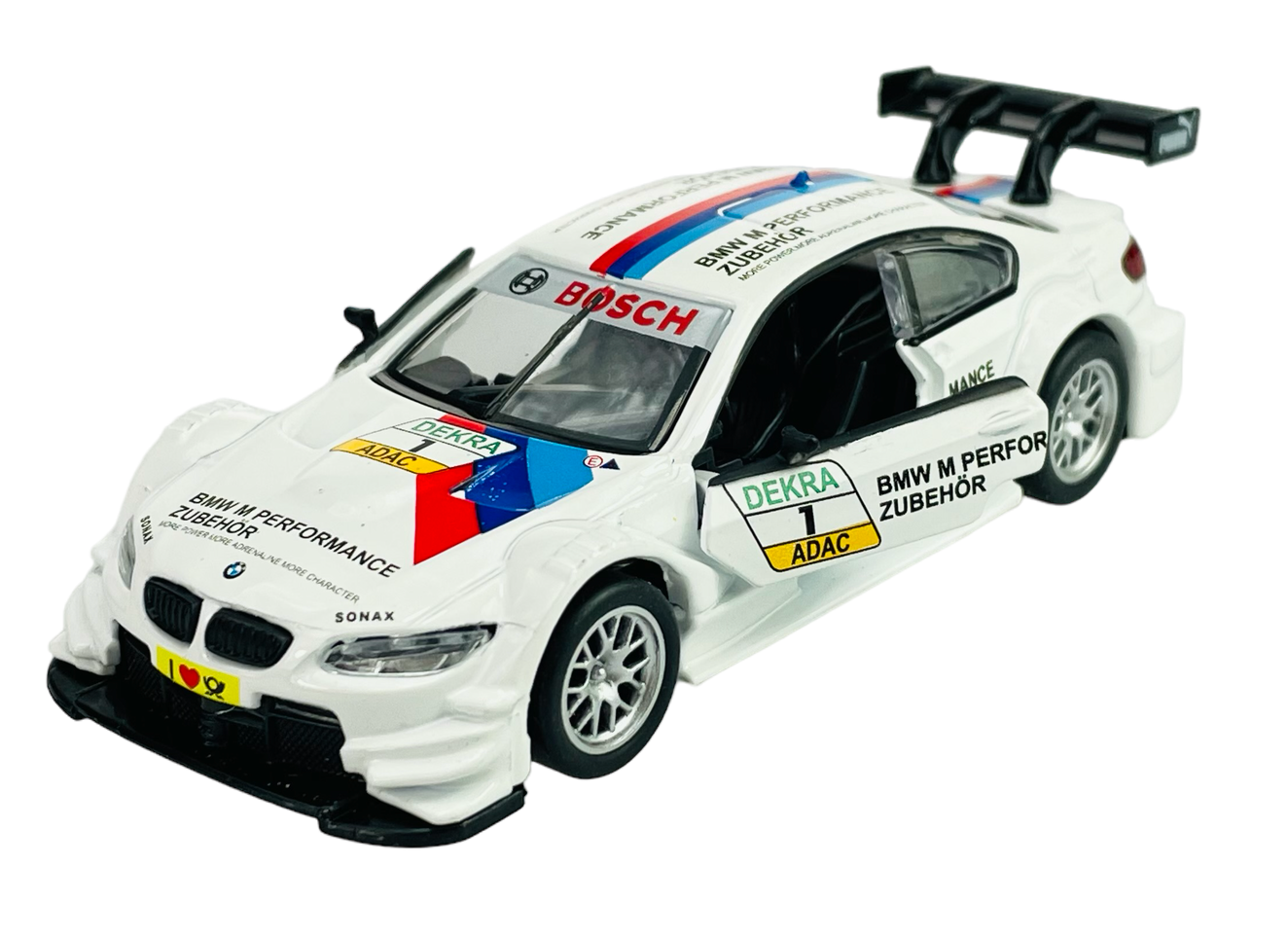 Model samochodu wyścigowego w skali 1:42, w kolorze białym z otwartymi drzwiami i widocznymi napisami \'BMW M PERFORMANCE ZUBEHÖR\', \'BOSCH\', \'DEKRA\', \'ADAC\'. Samochód posiada czarne detale, takie jak spojler i zderzak, oraz kolorowe paski na masce.
