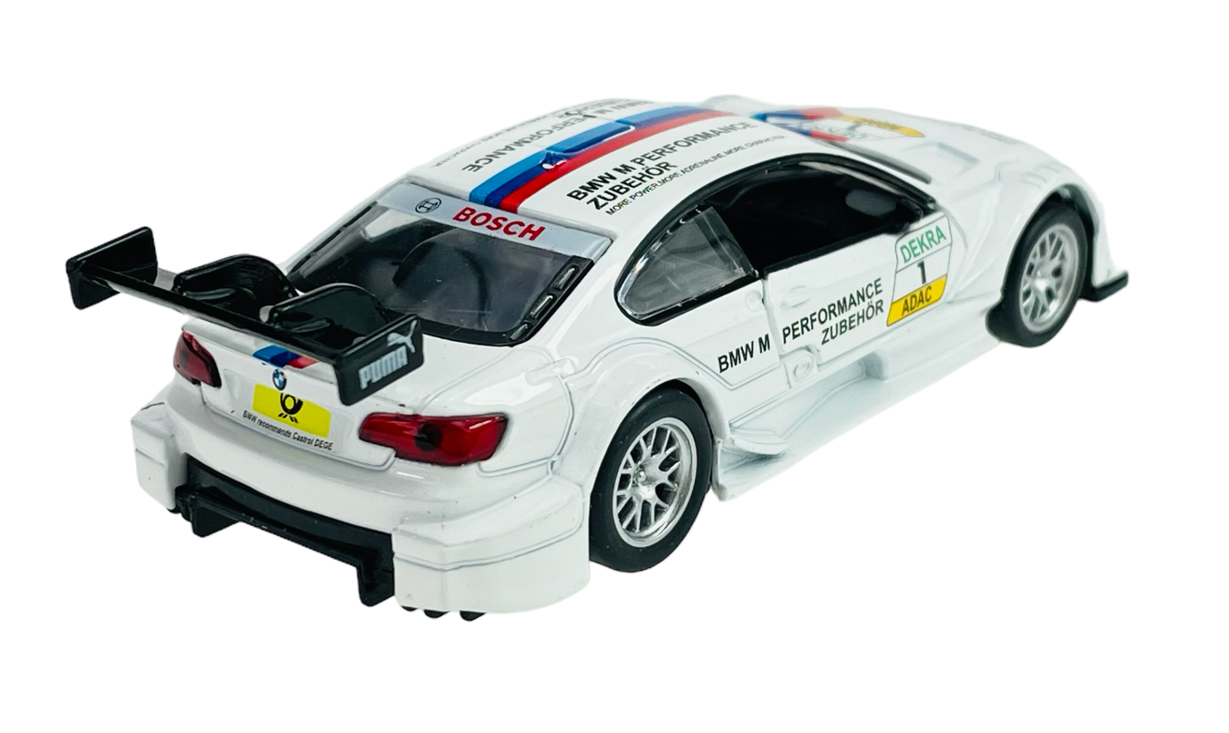 Model samochodu wyścigowego w skali 1:42, w kolorze białym z czarnym spojlerem i napisami \'BMW M PERFORMANCE ZUBEHÖR\', \'BOSCH\', \'DEKRA\', \'ADAC\'. Na tylnej szybie widoczne logo Puma, a na tablicy rejestracyjnej logo media expert.