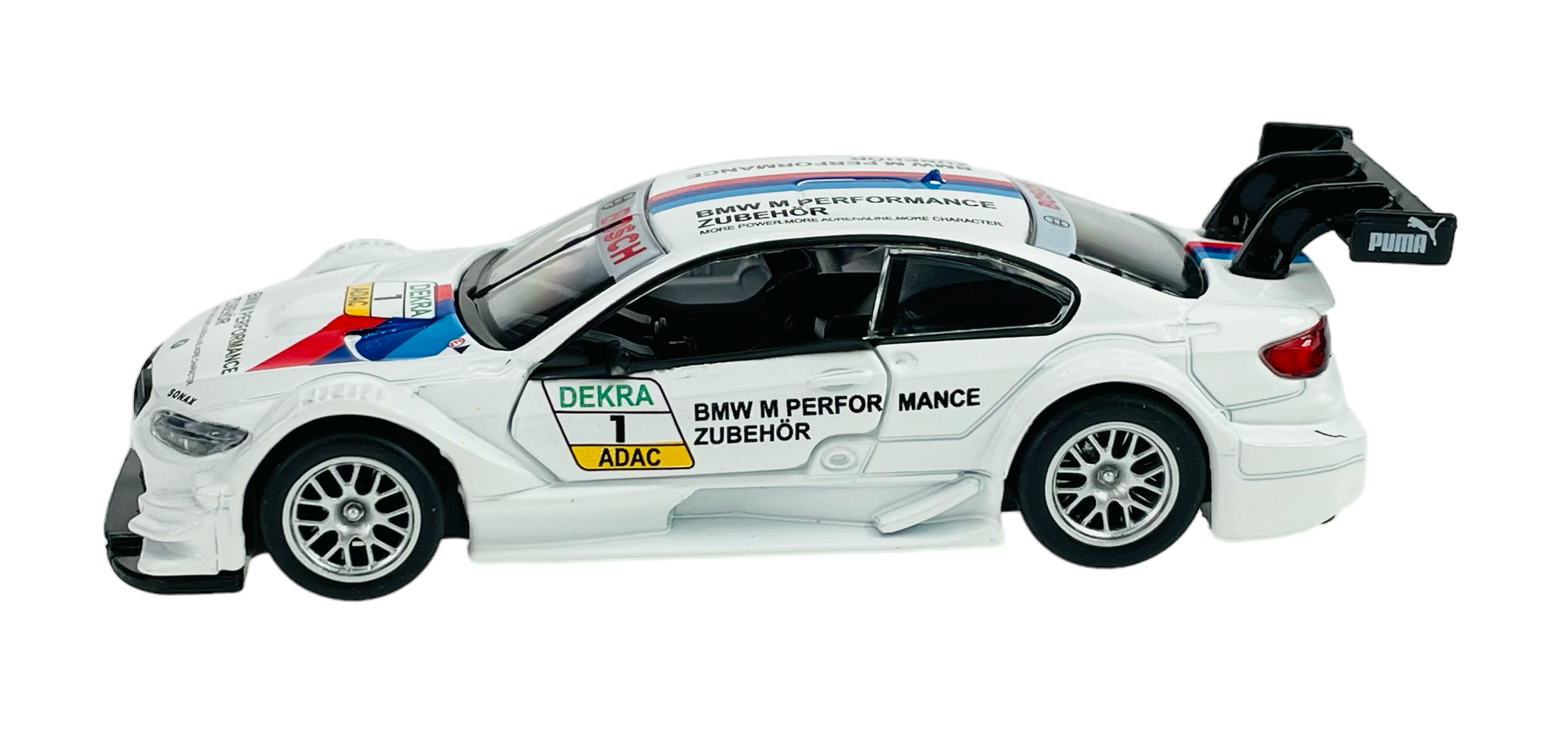 Model samochodu wyścigowego BMW M3 DTM w skali 1:42, w kolorze białym z czarnymi i czerwonymi detalami oraz napisami \'BMW M PERFORMANCE ZUBEHÖR\'. Na samochodzie widoczne są również logotypy \'DEKRA\', \'ADAC\' i \'PUMA\'.