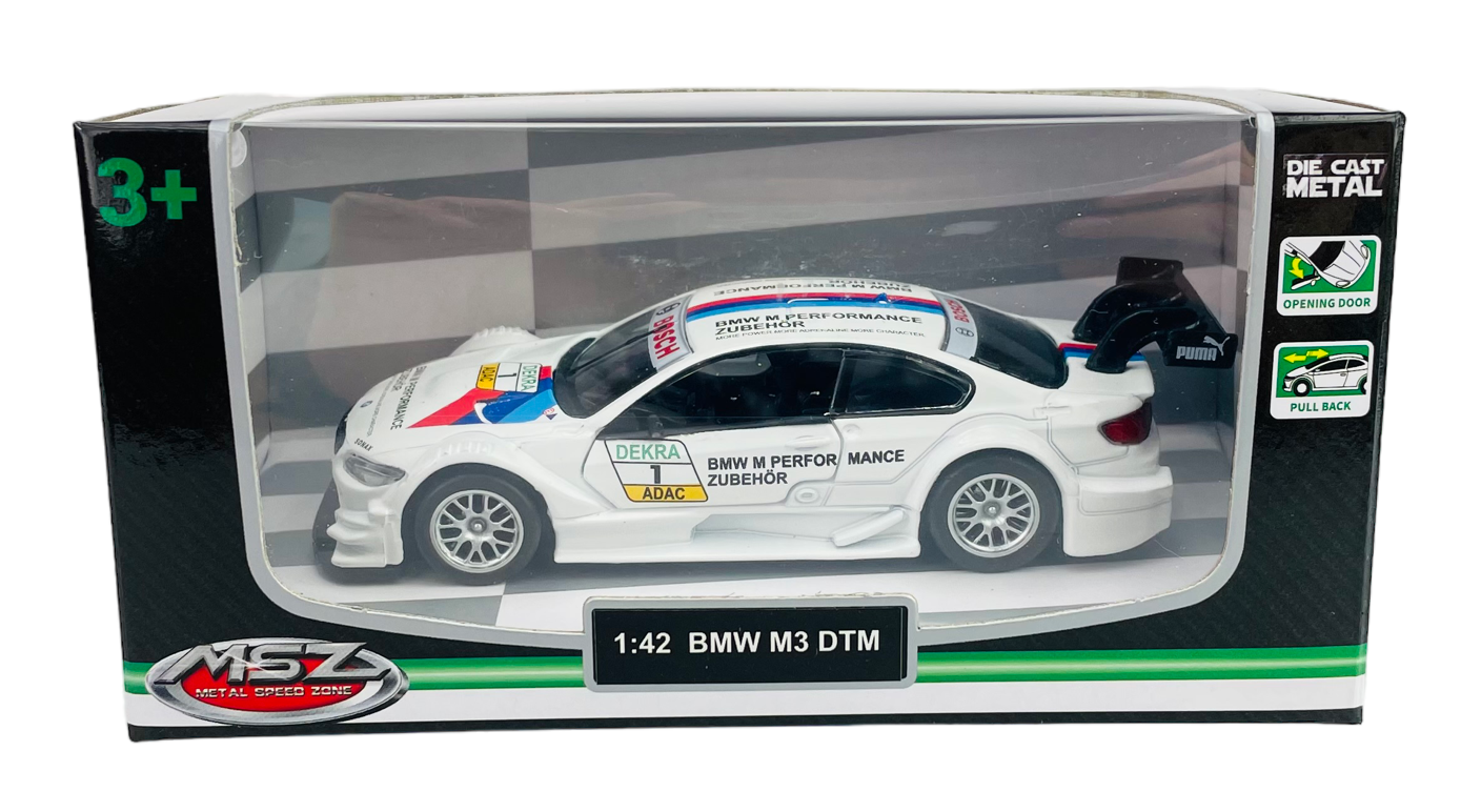 Model samochodu BMW M3 DTM w skali 1:42 w kolorze białym, umieszczony w przezroczystym opakowaniu z napisami \'DEKRA\', \'ADAC\', \'BMW M PERFORMANCE ZUBEHOR\'.