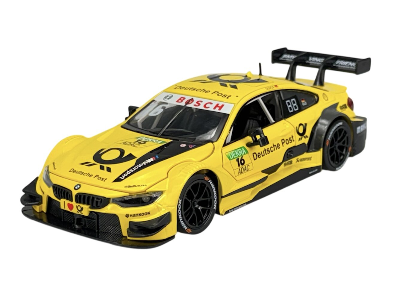 Żółty model samochodu wyścigowego z logo Deutsche Post i napisem \'BOSCH\' na przedniej szybie. Na karoserii widoczne są również inne logotypy i oznaczenia, takie jak \'DEKRA\' i \'ADAC\'.