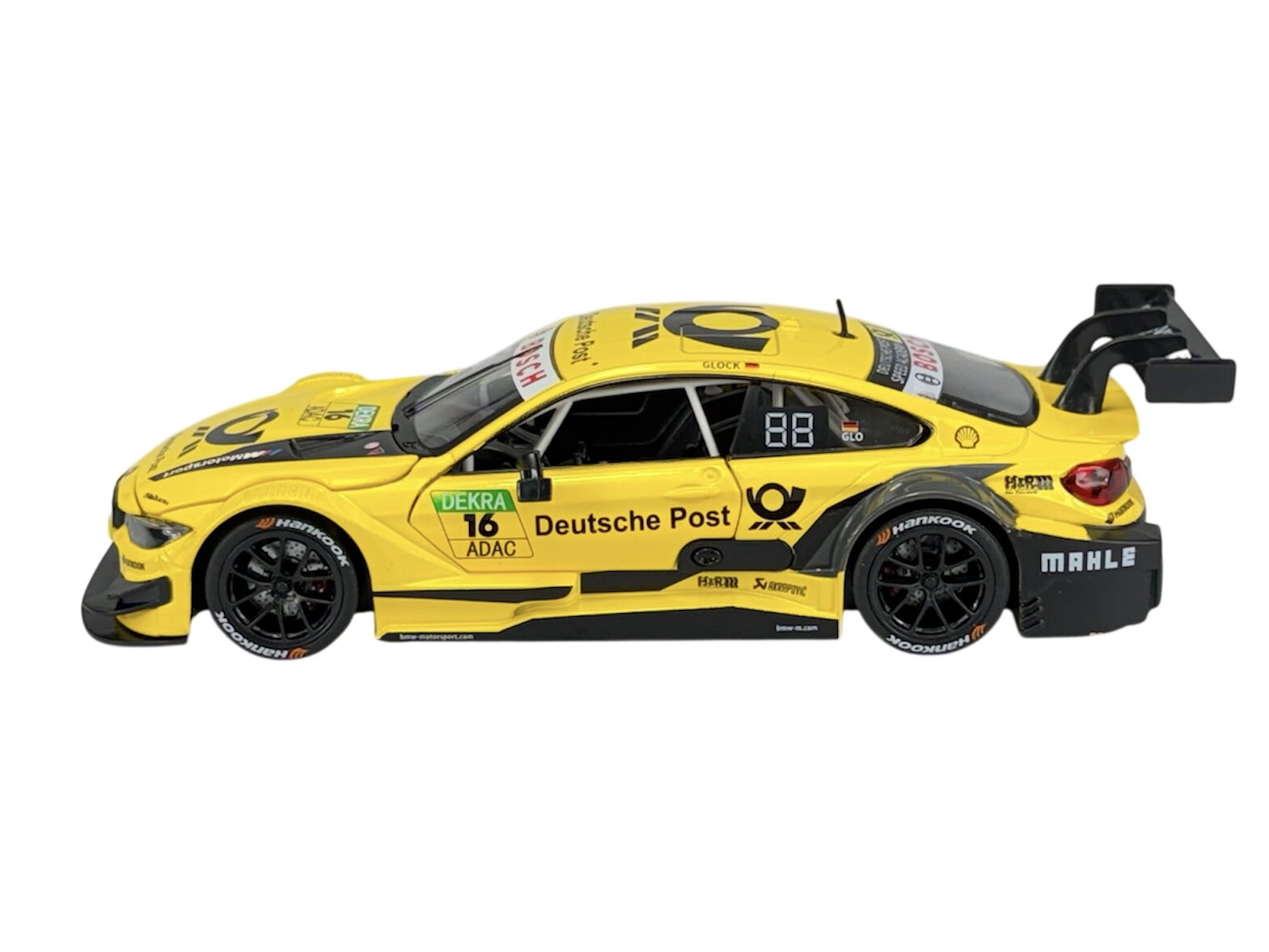 Model samochodu wyścigowego w skali 1:24, w kolorze żółtym z czarnymi detalami i napisami \'Deutsche Post\'. Na karoserii widoczne są logotypy sponsorów oraz numer 16.