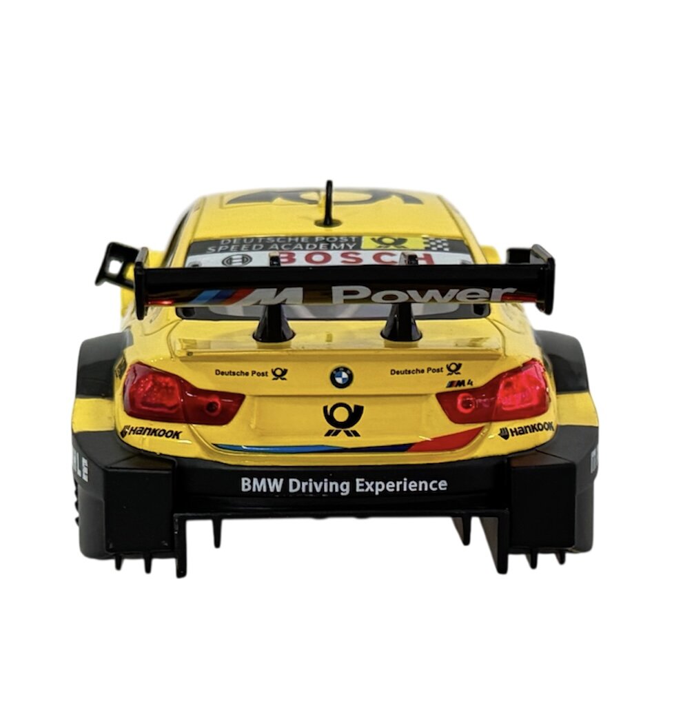Model samochodu wyścigowego w kolorze żółtym z widocznymi napisami \'M Power\' na spojlerze i \'BMW Driving Experience\' na zderzaku. Na karoserii znajdują się logotypy i napisy, w tym \'Deutsche Post\' i \'Hankook\'.