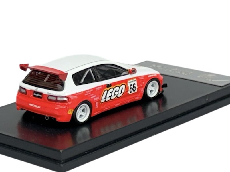 Model samochodu w skali 1:64 przedstawia czerwono-biały pojazd z logo \'LEGO\' i numerem \'56\' na boku. Samochód umieszczony jest na czarnej podstawce.