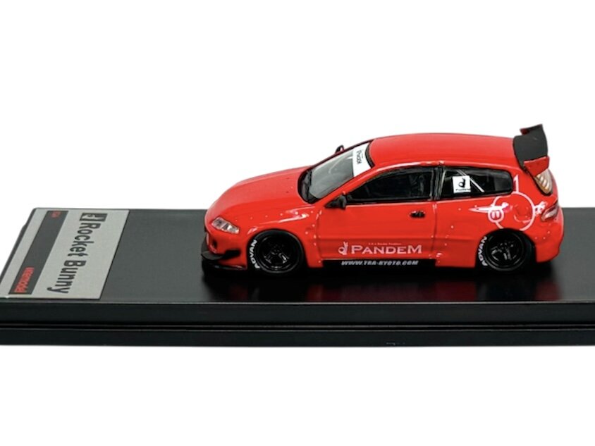 Czerwony model samochodu z napisem \'Pandem\' na boku, umieszczony na czarnej podstawce z etykietą \'Rocket Bunny\'.