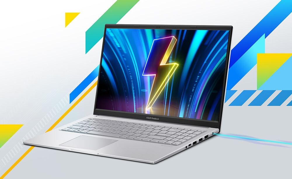 Na obrazie widoczny jest laptop z ekranem wyświetlającym kolorową grafikę z błyskawicą. Obudowa laptopa jest srebrna, a na dolnej ramce ekranu znajduje się napis \'ASUS Vivobook\'.