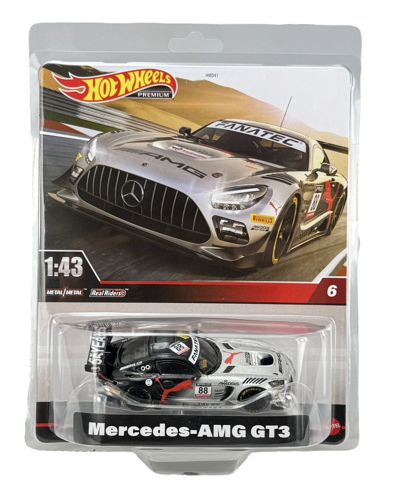Opakowanie z modelem samochodu wyścigowego Mercedes-AMG GT3 w skali 1:43, z logo Hot Wheels Premium. Widoczny jest srebrny samochód z czarnymi i czerwonymi detalami oraz napisami \'AMG\' i \'FANATEC\'.