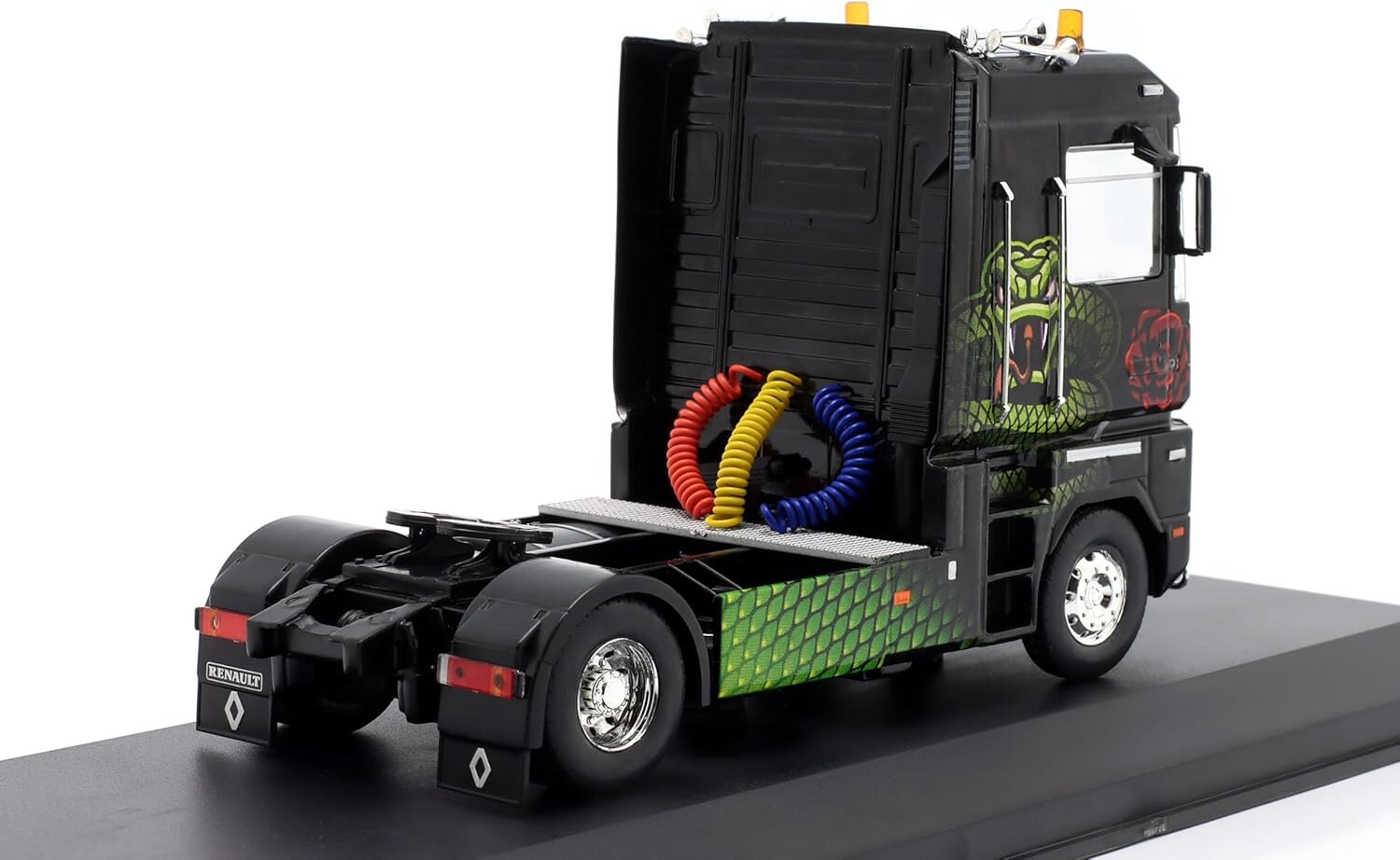 Model ciężarówki w skali 1:43 z czarną kabiną ozdobioną grafiką węża i kolorowymi przewodami z tyłu. Na zderzaku widoczne jest logo Renault.