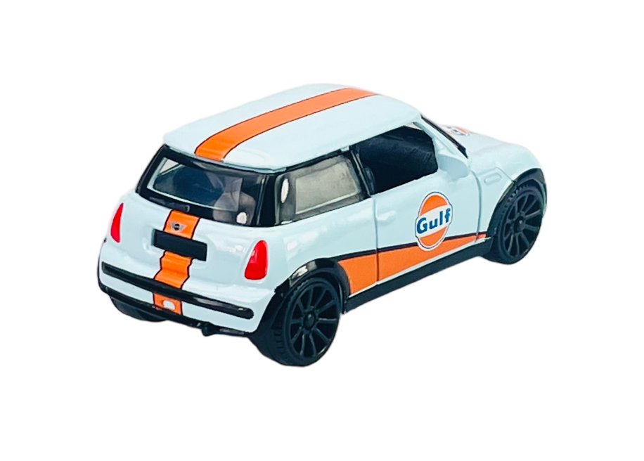 Model samochodu w skali 1:43, przedstawiający Mini Cooper w kolorze jasnoniebieskim z pomarańczowymi pasami i logo \'Gulf\' na boku. Samochód ma czarne felgi i szczegółowo odwzorowane elementy karoserii.