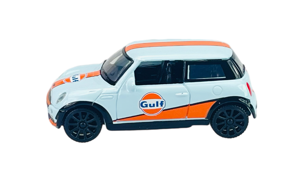 Model samochodu Mini Cooper w skali 1:43, w kolorze białym z pomarańczowymi pasami i logo \'Gulf\' na boku. Posiada czarne felgi i szczegółowe wykończenia.