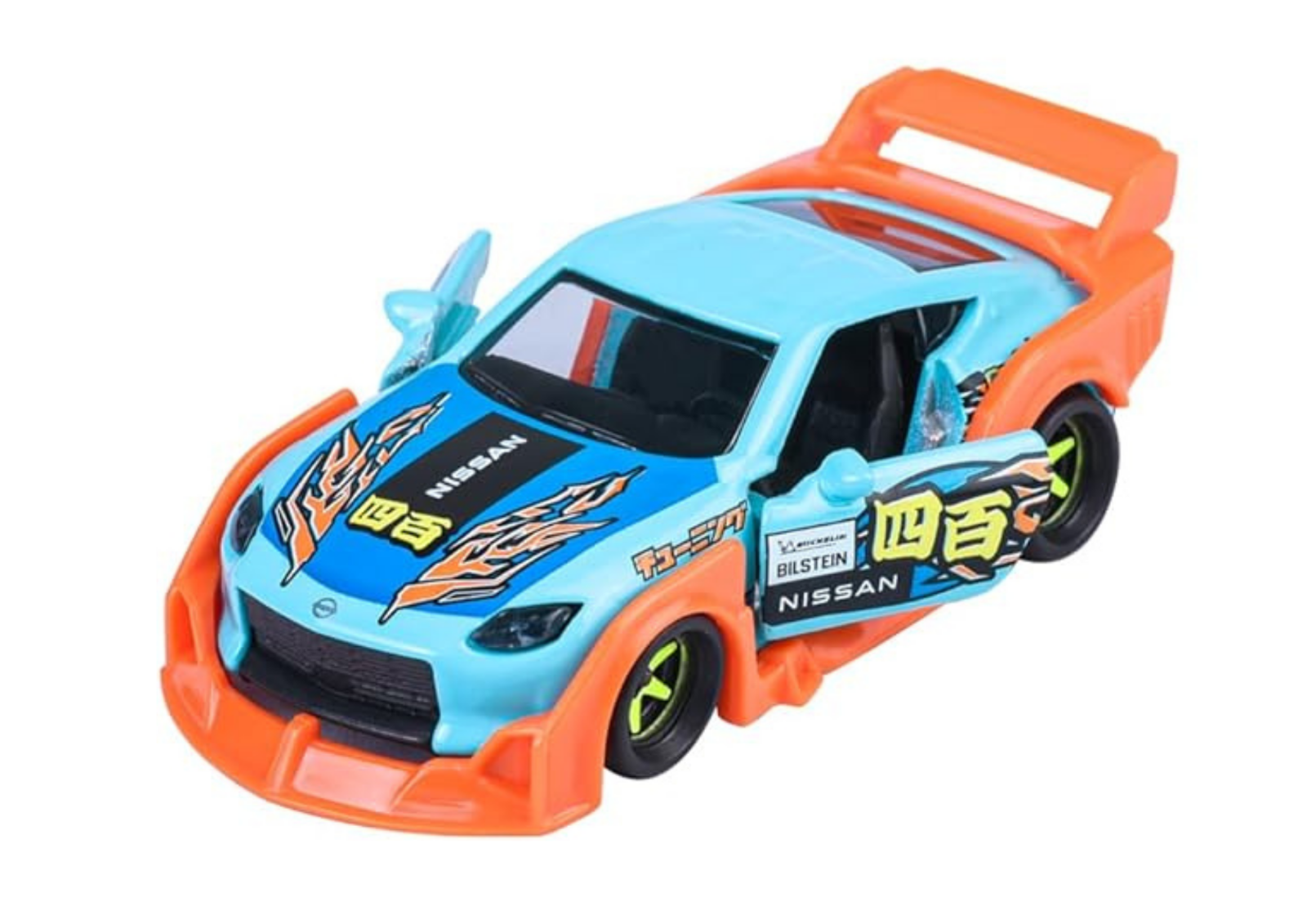 Model samochodu w skali 1:64 w kolorze niebieskim z pomarańczowymi akcentami i otwartymi drzwiami. Na masce i bokach widoczne są napisy i grafiki, w tym \'NISSAN\' i \'BILSTEIN\'.