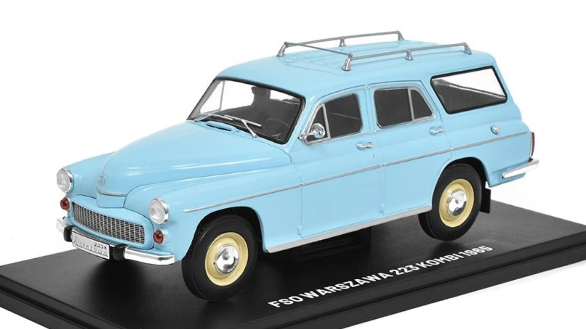 Model samochodu w kolorze niebieskim z białymi i żółtymi detalami, umieszczony na czarnej podstawce z napisem \'FSO WARSZAWA 223 KOMBI 1965\'.