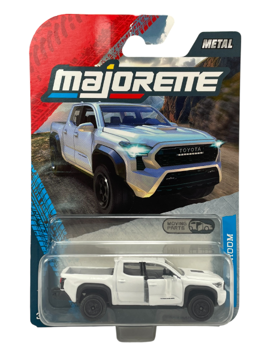 Opakowanie z metalowym modelem samochodu Majorette przedstawiające białą Toyotę Tacoma TRD PRO w skali 1:64. Na opakowaniu widoczne są napisy: \'Majorette\', \'Metal\', \'Moving Parts\'.