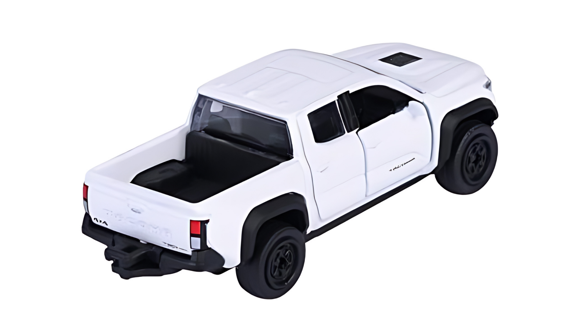 Model samochodu w skali 1:64 przedstawiający biały pickup z czarnymi kołami i otwartą przestrzenią ładunkową. Na tylnej klapie widoczny jest napis \'TACOMA\'.