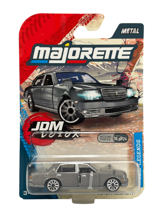 Opakowanie modelu samochodu Majorette z napisem \'JDM Legends\' i grafiką srebrnego auta. Widoczny jest napis \'METAL\' oraz ikona \'MOVING PARTS\'.