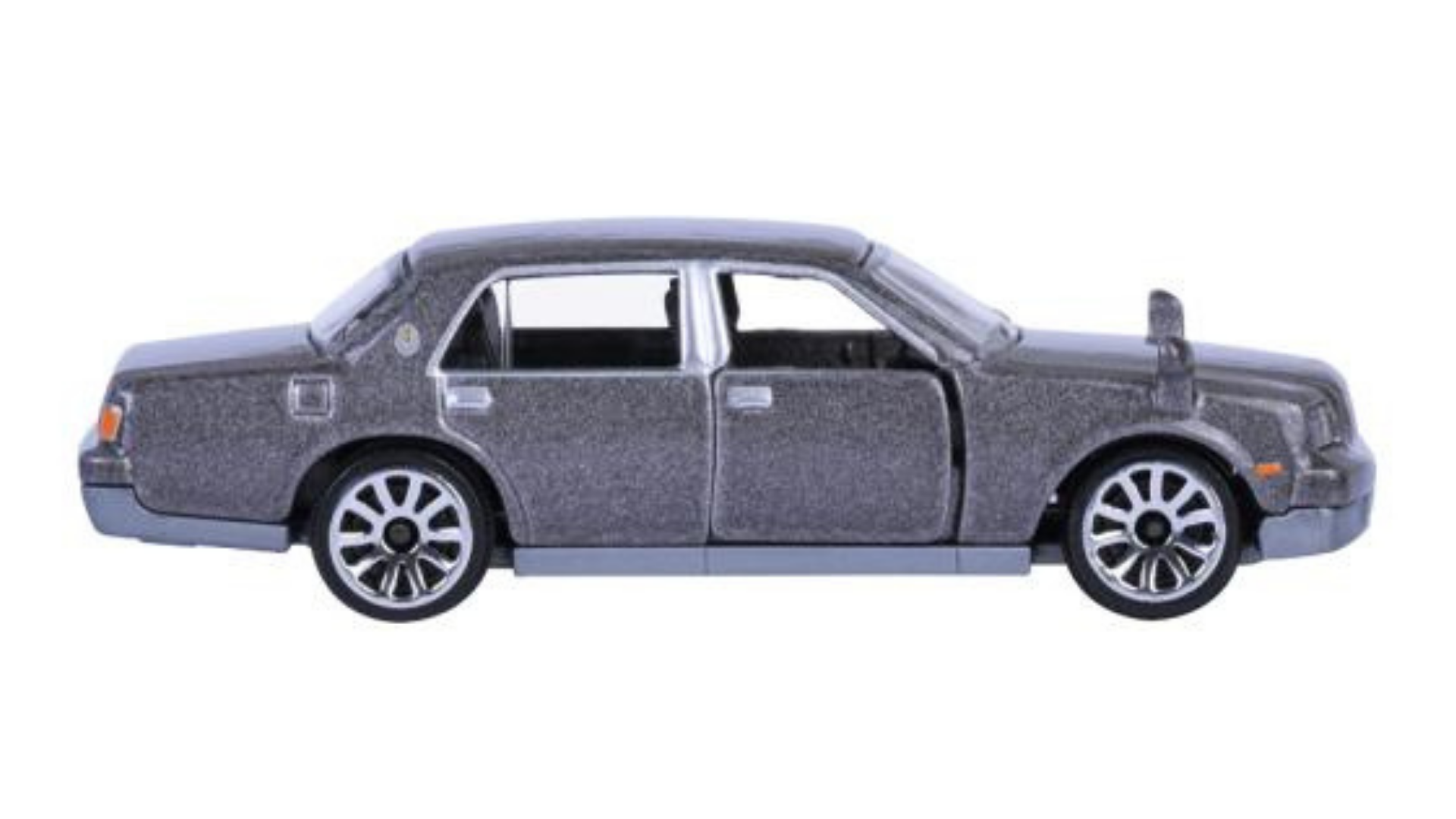 Model samochodu w skali 1:64, przedstawiający srebrny pojazd z czterema drzwiami i szczegółowymi felgami. Samochód ma metaliczne wykończenie i widoczne detale, takie jak lusterka i klamki.
