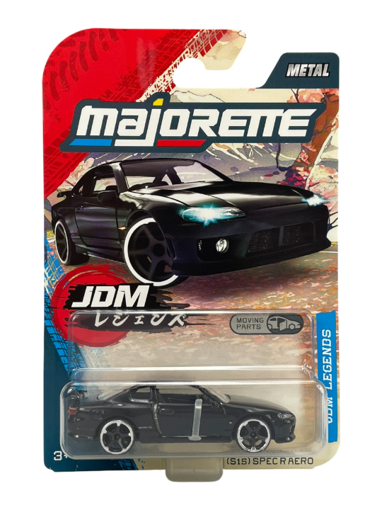 Opakowanie z modelem samochodu Majorette JDM Legends, przedstawiające czarny Nissan Silvia (S15) Spec R Aero w skali 1:64. Na opakowaniu widoczne są napisy: \'majorette\', \'JDM\', \'METAL\', \'MOVING PARTS\'.