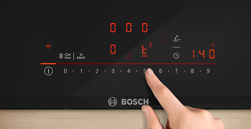 Czarna płyta indukcyjna z dotykowym panelem sterowania, na którym widoczne są cyfry i symbole w kolorze czerwonym. Logo BOSCH znajduje się na dolnej części płyty.