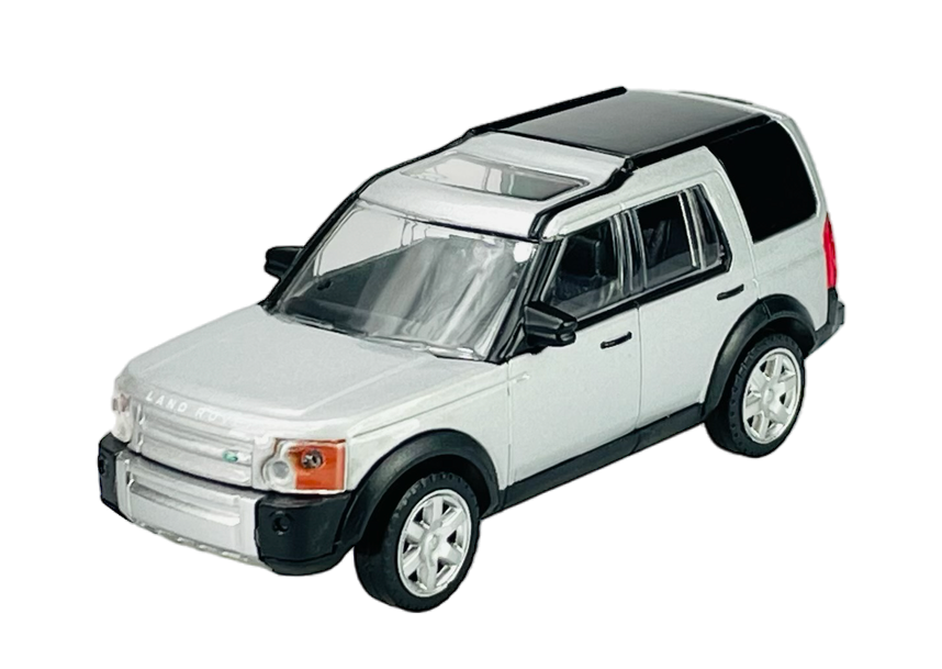 Srebrny model samochodu terenowego z czarnym dachem i białymi felgami. Na przodzie widoczny napis \'LAND ROVER\'.