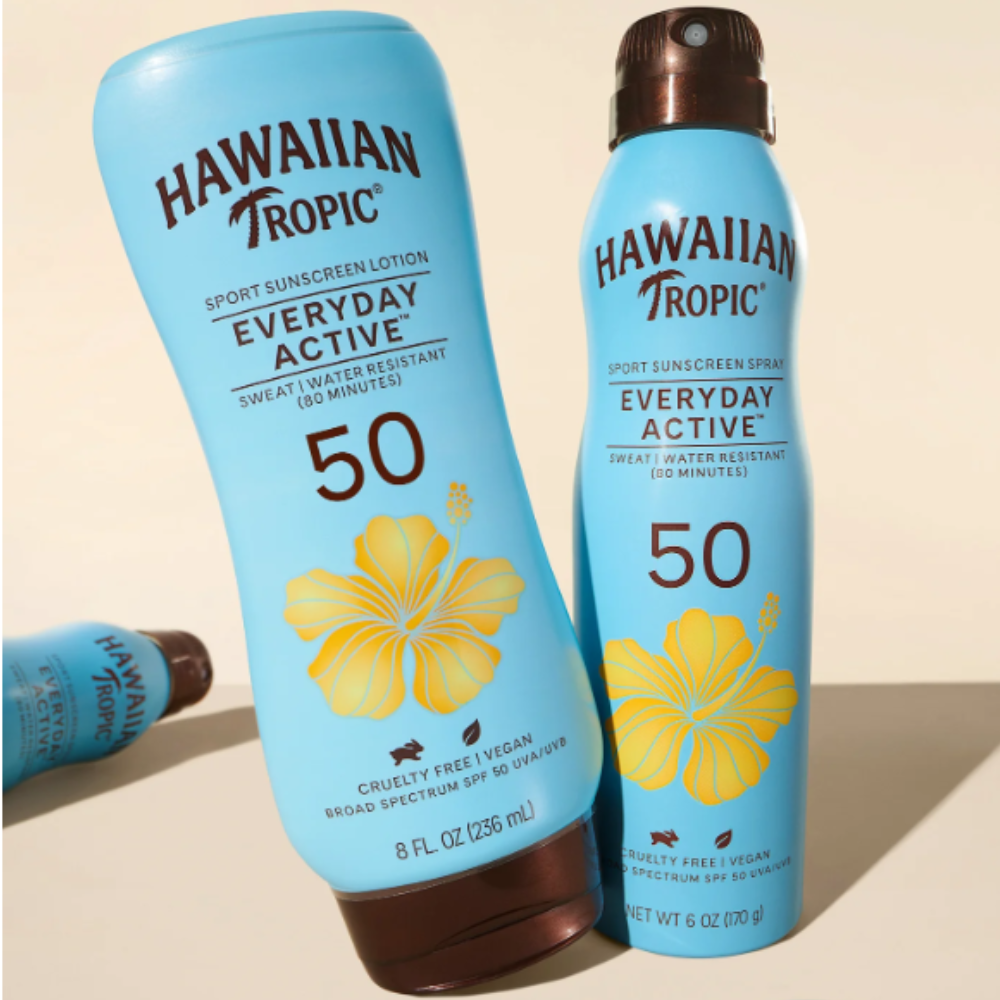 Na obrazie widoczne są dwa niebieskie opakowania produktów marki Hawaiian Tropic z napisem \'SPORT SUNSCREEN LOTION EVERYDAY ACTIVE 50\' oraz \'SPORT SUNSCREEN SPRAY EVERYDAY ACTIVE 50\'. Oba produkty mają żółty motyw kwiatu i informację \'CRUELTY FREE | VEGAN BROAD SPECTRUM SPF 50 UVA/UVB\'.
