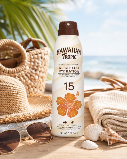 Na obrazie znajduje się spray do opalania Hawaiian Tropic z SPF 15, umieszczony na tle plażowych akcesoriów, takich jak kapelusz, okulary przeciwsłoneczne i muszle. Na opakowaniu widnieje napis: \'HAWAIIAN Tropic WEIGHTLESS HYDRATION 15\'.